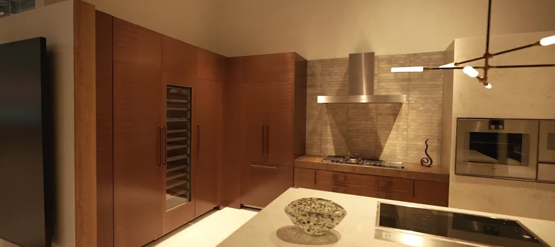 Modern walnut kitchen with a white stone island, made by NIC Cabinetry