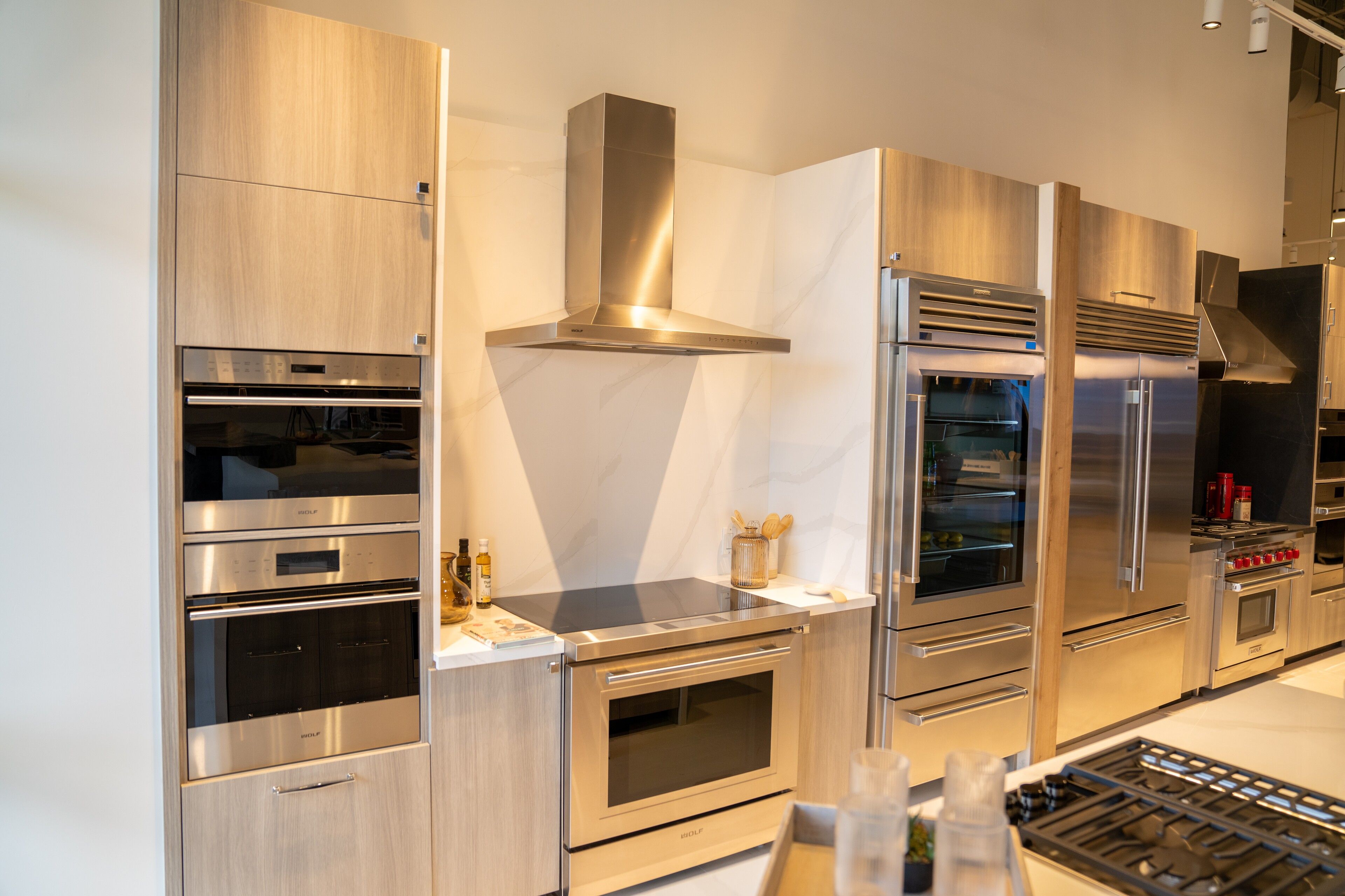 White oak kitchen with a marble waterfall hood