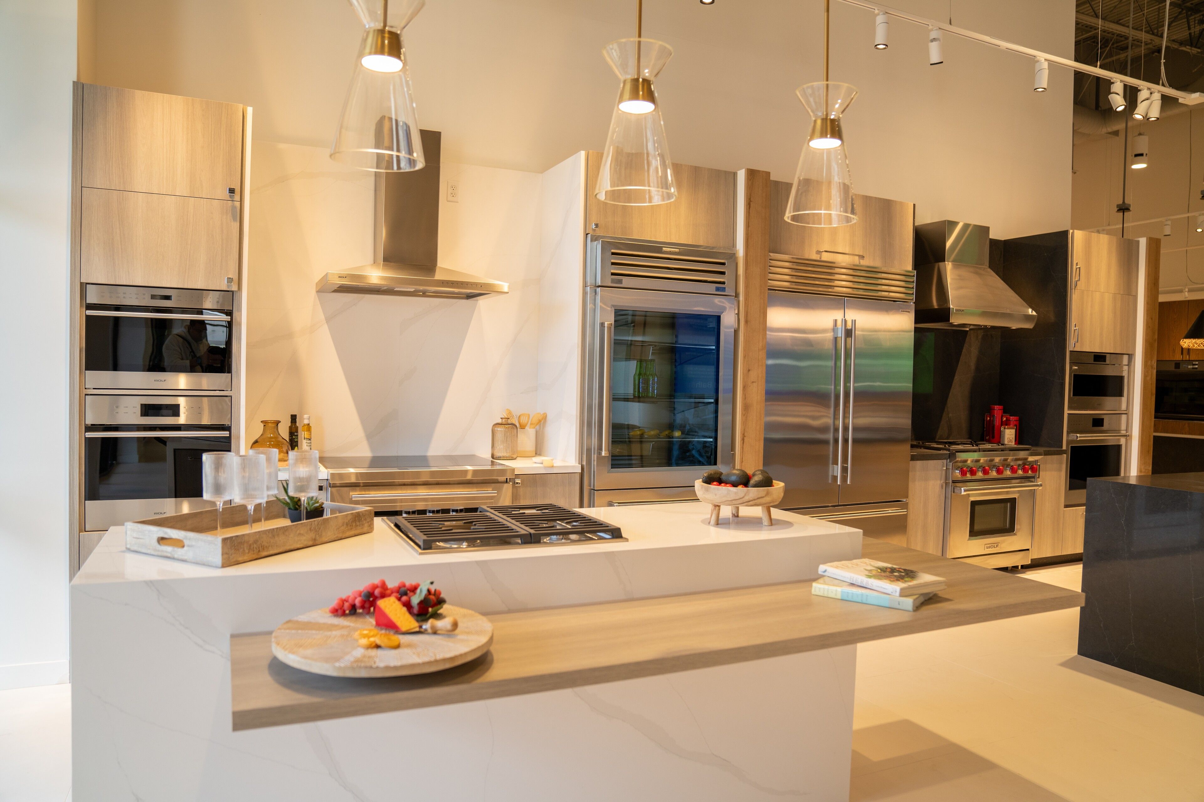 Light oak cabinetry, a white waterfall island and blown-glass pendants