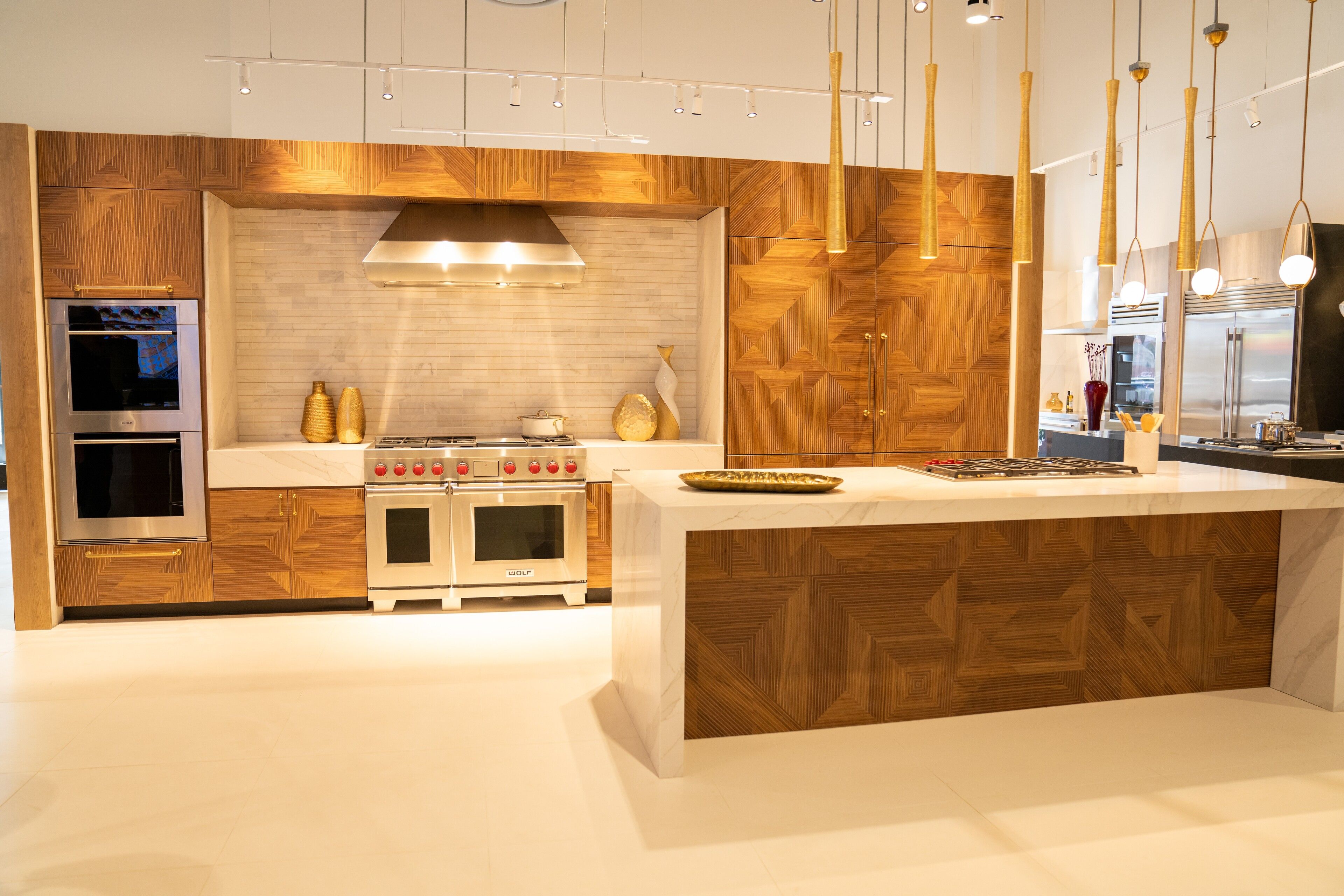 Walnut herringbone paneling, brass pulls and a marble waterfall island