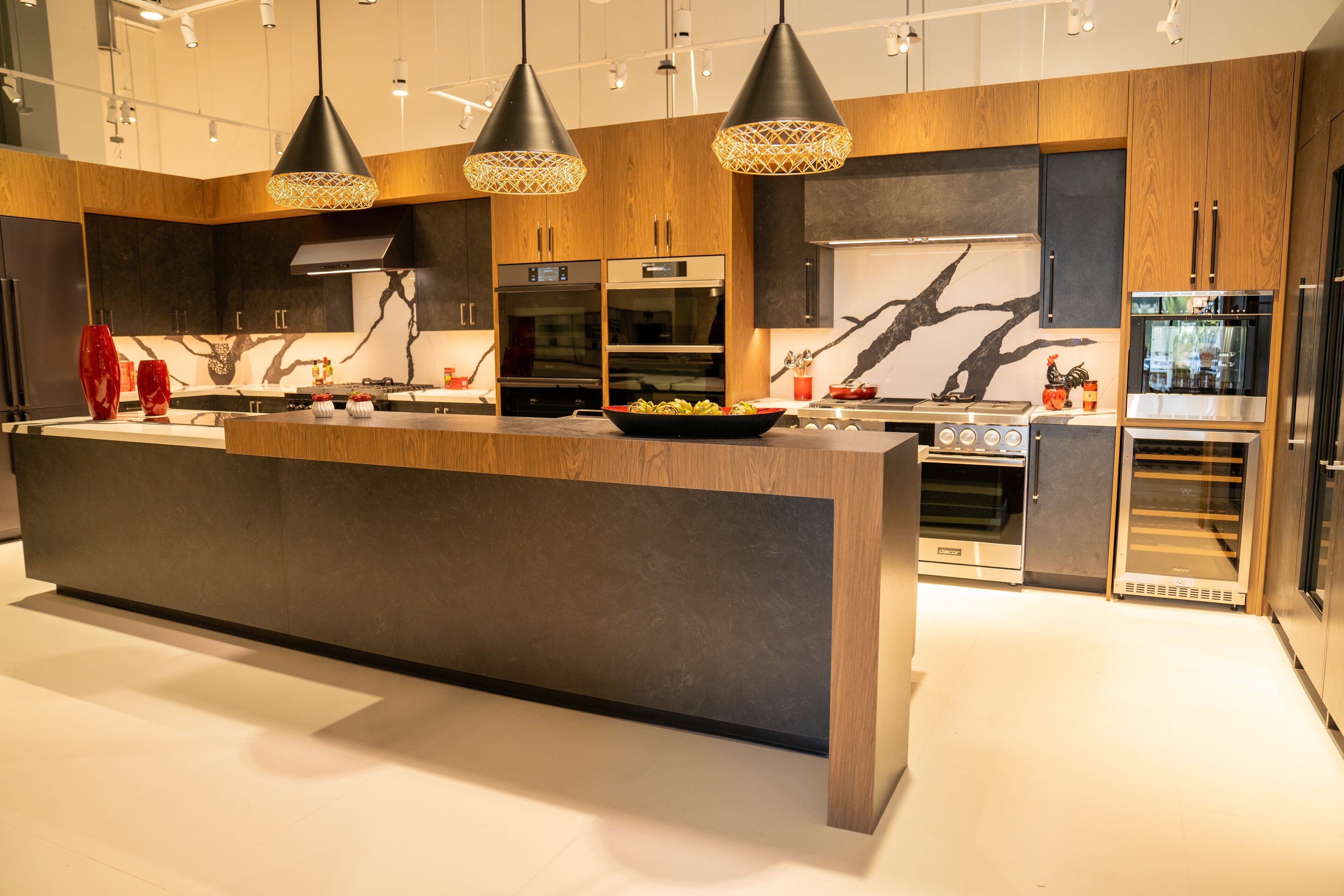 Walnut and charcoal cabinetry with a bold marble island and backsplash