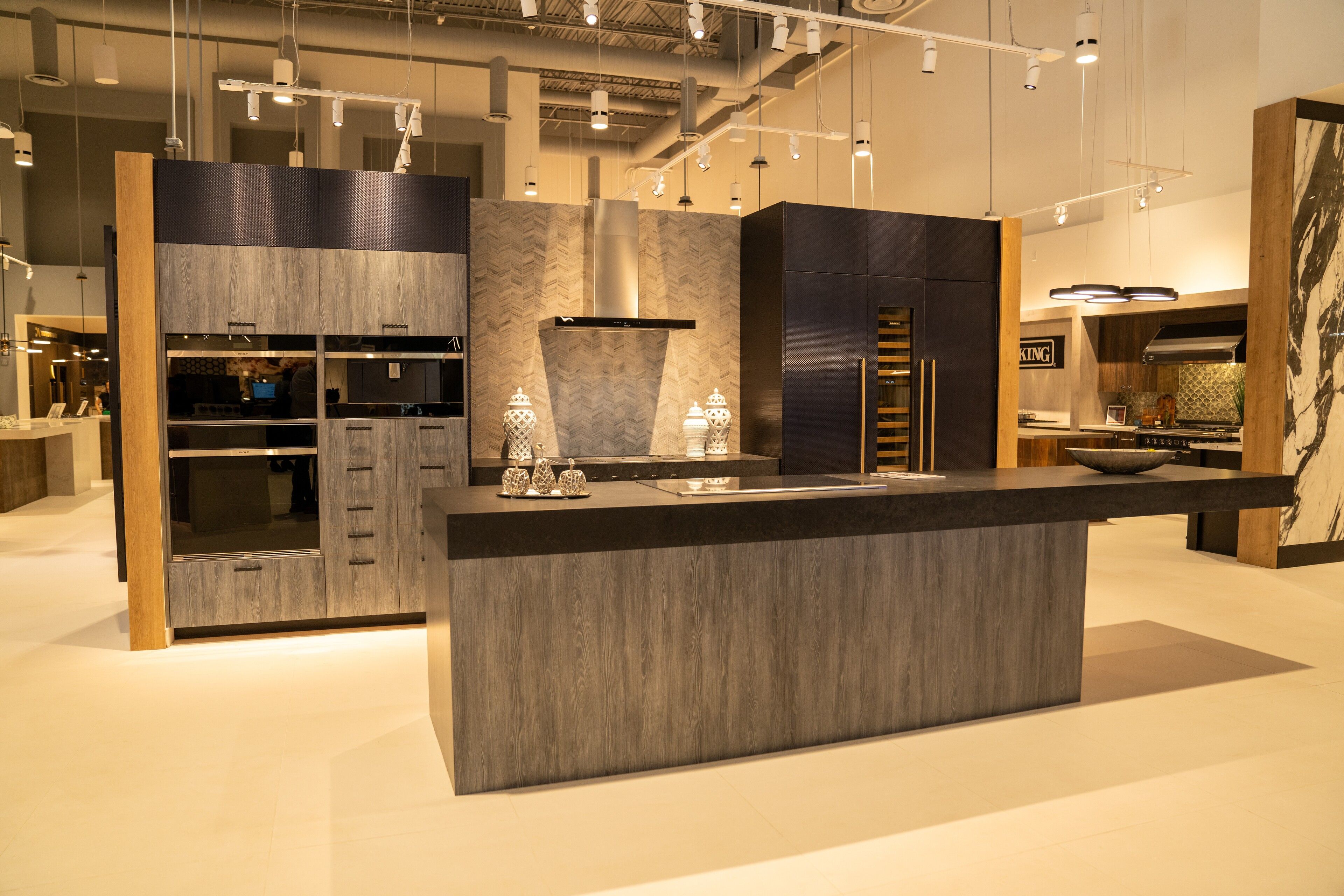Black slab cabinetry framed in oak with a marble backsplash
