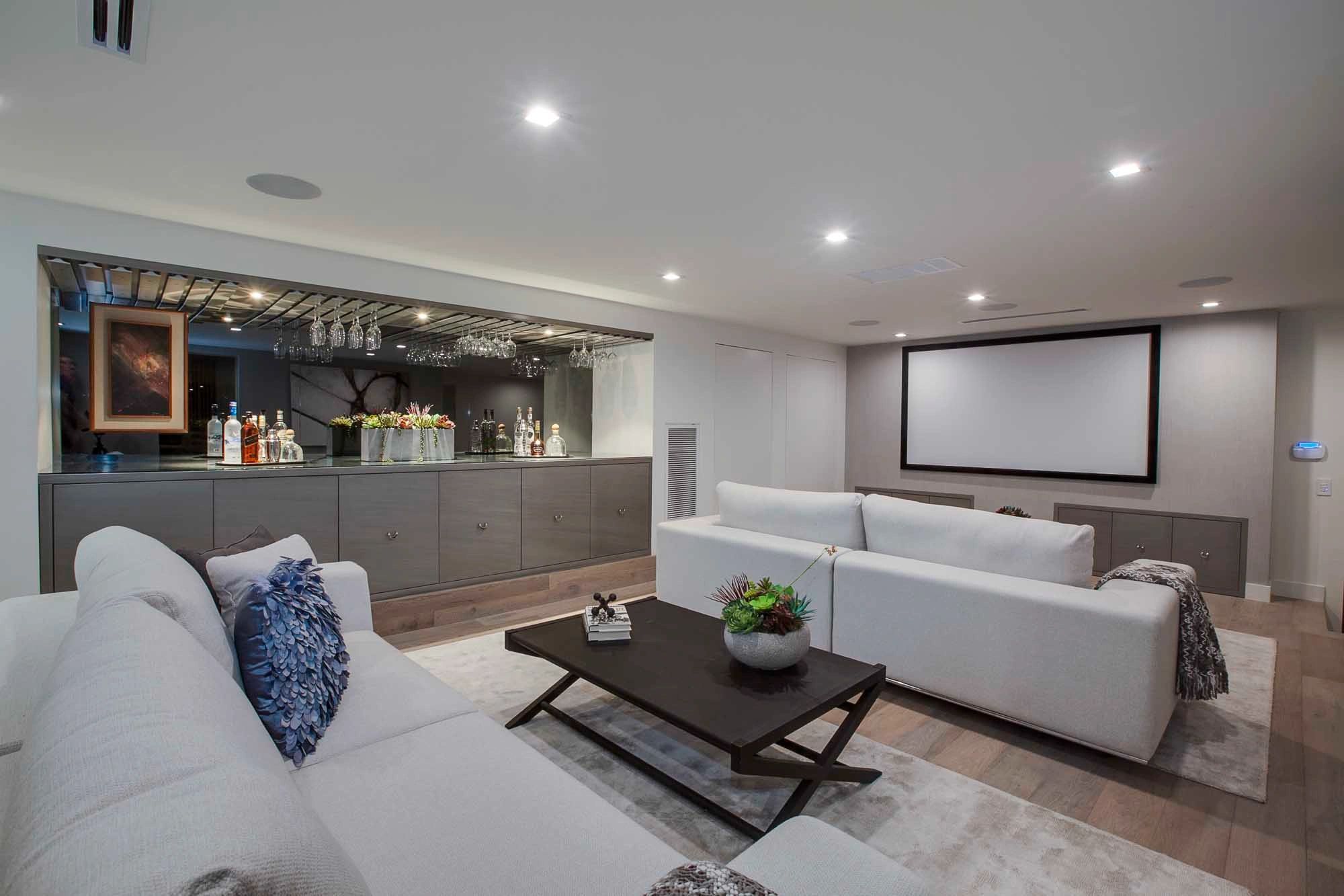 Dark grey slab media cabinets and bar in an open living room
