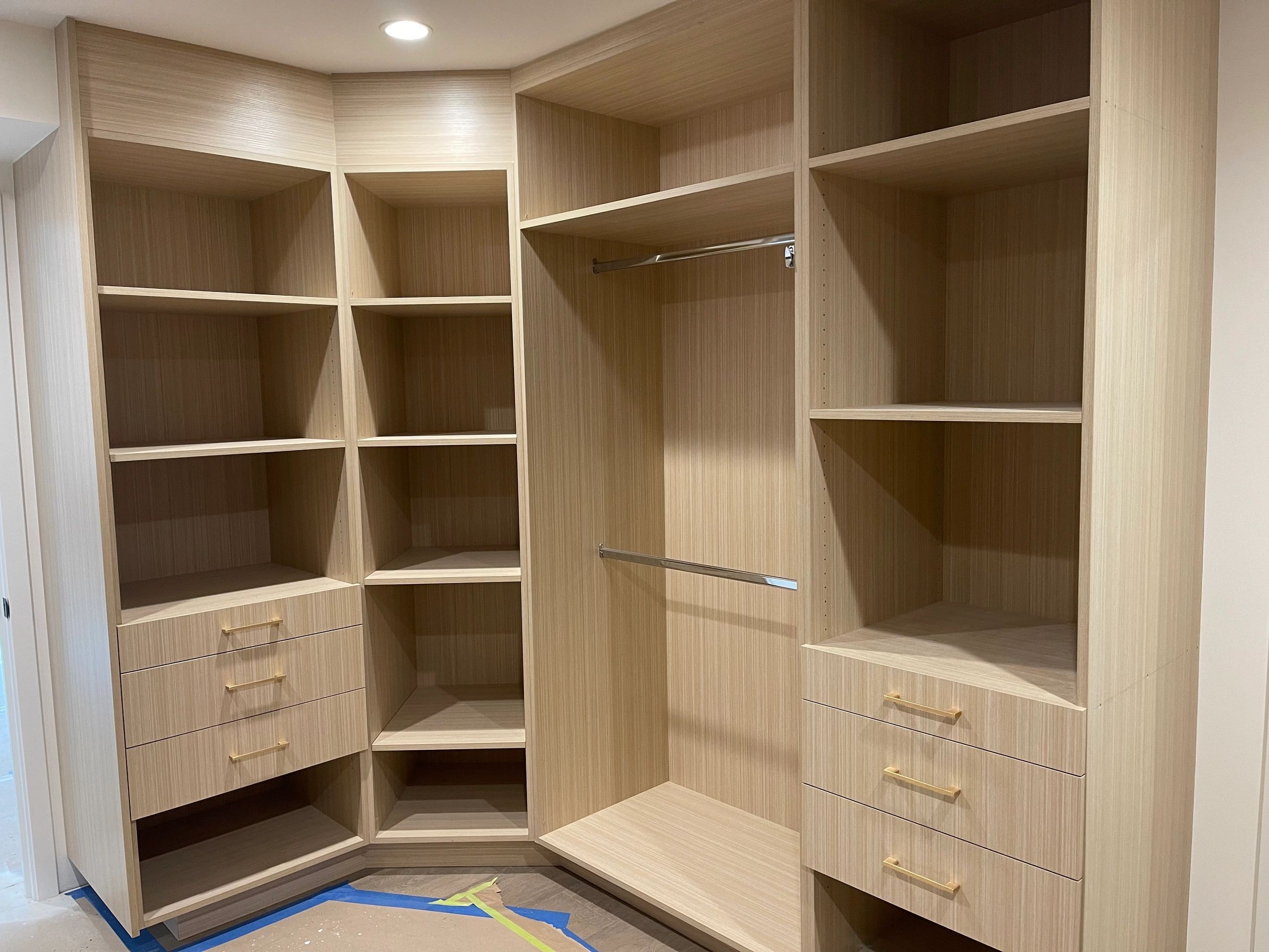 Walk-in closet, light wood drawers and shelves