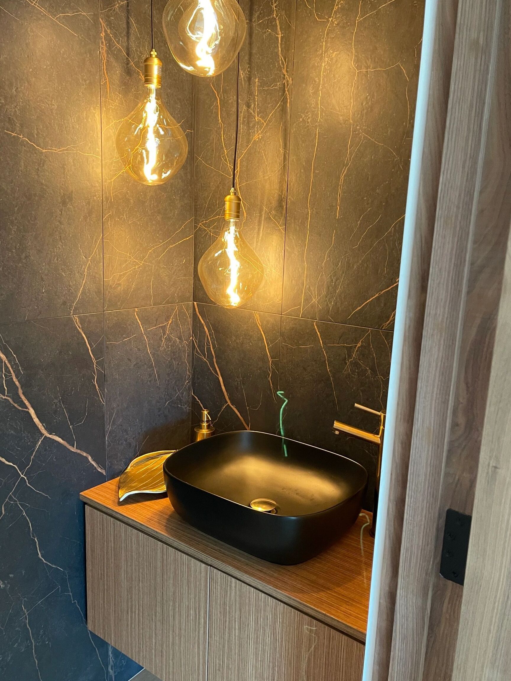 Floating light oak vanity cabinet with black vessel sink - custom cabinetry by NIC Cabinetry