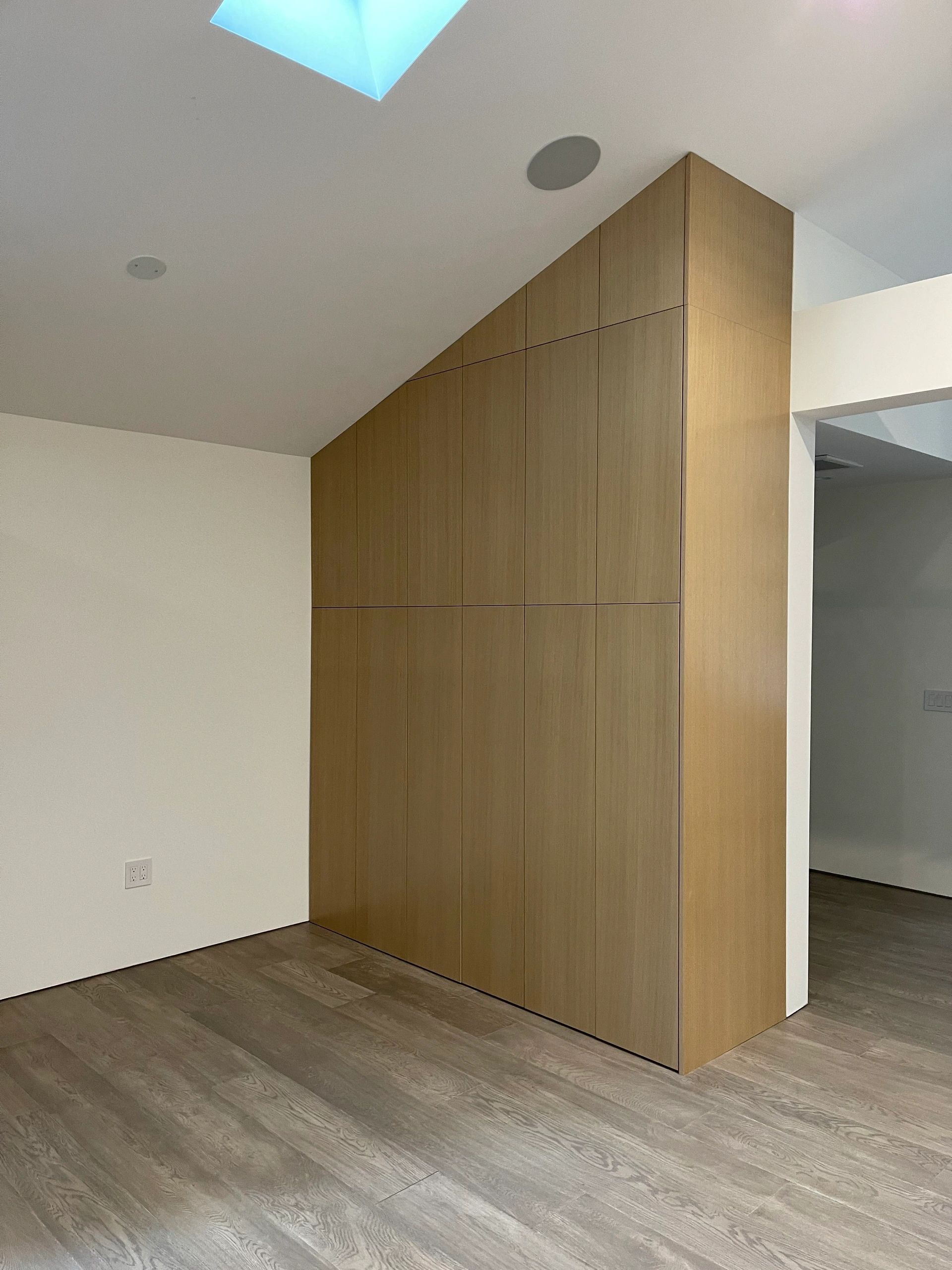 Modern light oak wardrobe closet unit built under a slanted ceiling